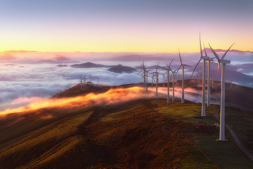 Windkraftanlagen auf einem Berg über den Wolken.